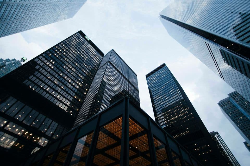 Skyscrapers photographed from street level against a pale sky, a scale a small site should not try to imitate when it says who it is for.