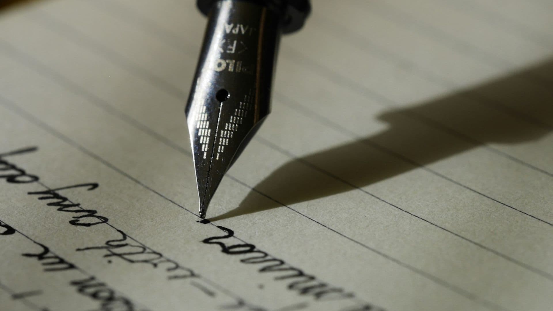 A close view of a fountain pen writing on lined paper. A useful brief is a short piece of writing, not a long presentation.